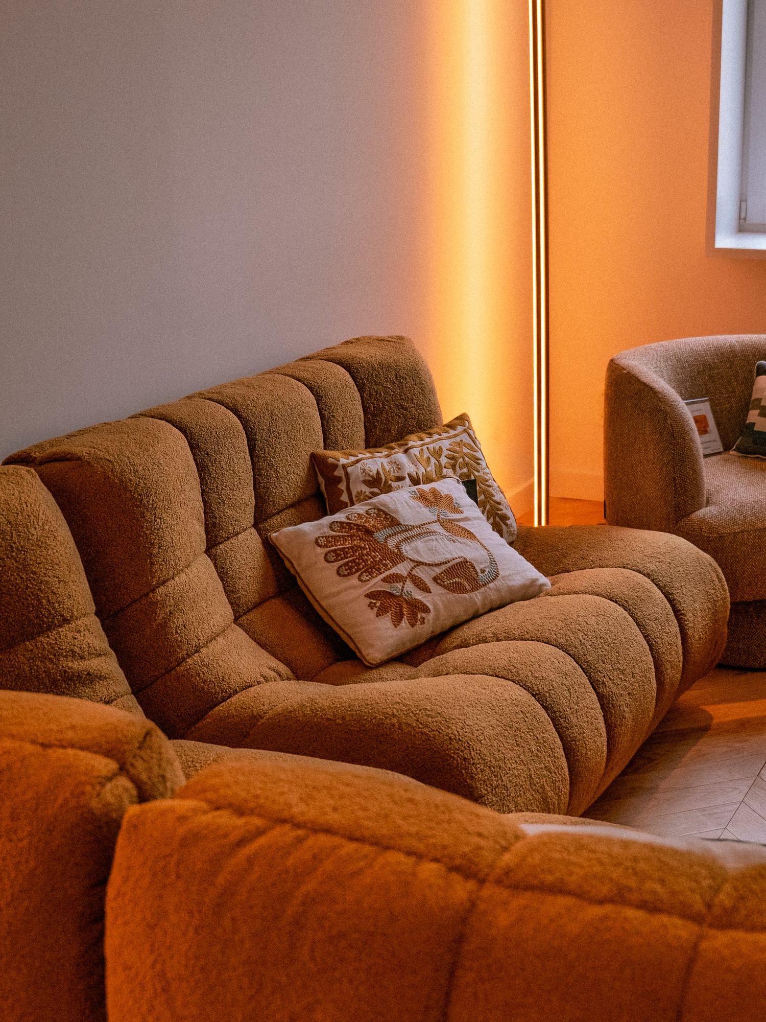 Canapés en tissu bouclette mis en lumière dans le showroom Archivolte